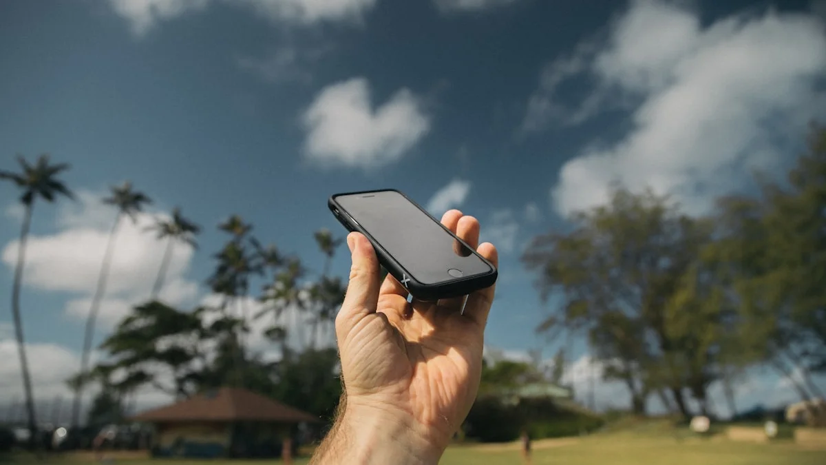 A hand holds a black smartphone up against a wide sky. — a The Obsidian Key guide to The Guilt Text: Answering From the Seat.