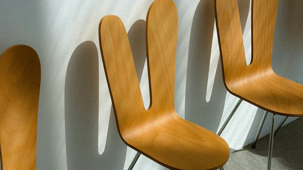 Curved light-wood chairs with rounded backs lean against a white wall in soft window light. — a The Obsidian Key guide to A Chair Is Not the Bed: the Posture That Tunes You.