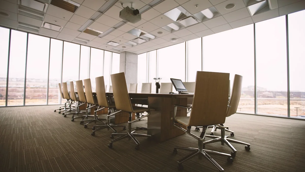 An empty conference room holds a long table, office chairs, and tall windows under flat light. — a The Obsidian Key guide to Colleagues Who Lean: The Office Weather.
