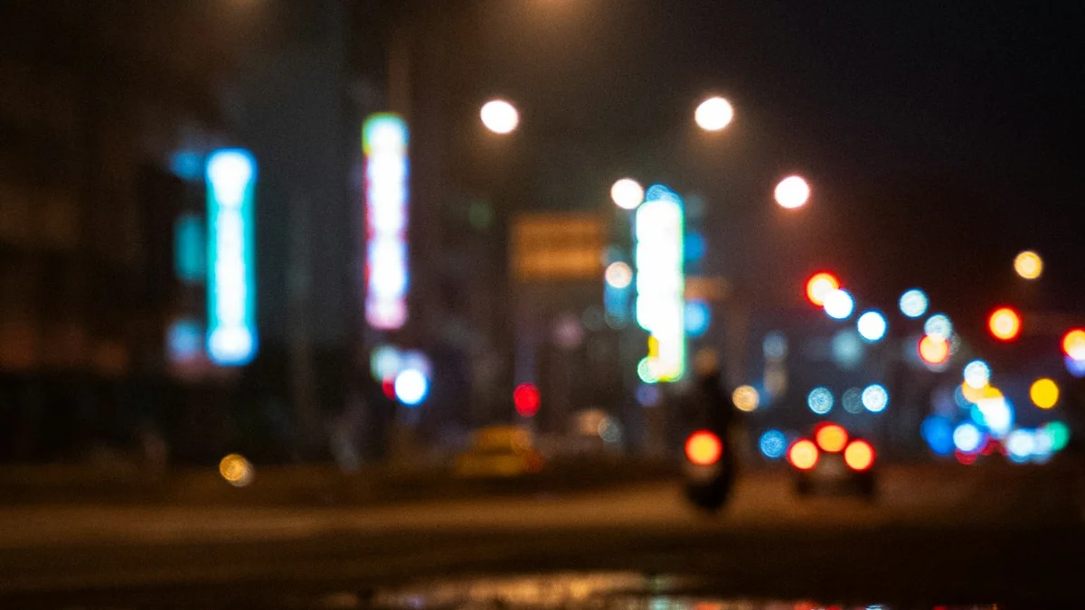 Blurred shop lights glowing over a rain-slicked night street. — a The Obsidian Key guide to Emotional Spending: Leakage in Its Purest Form.