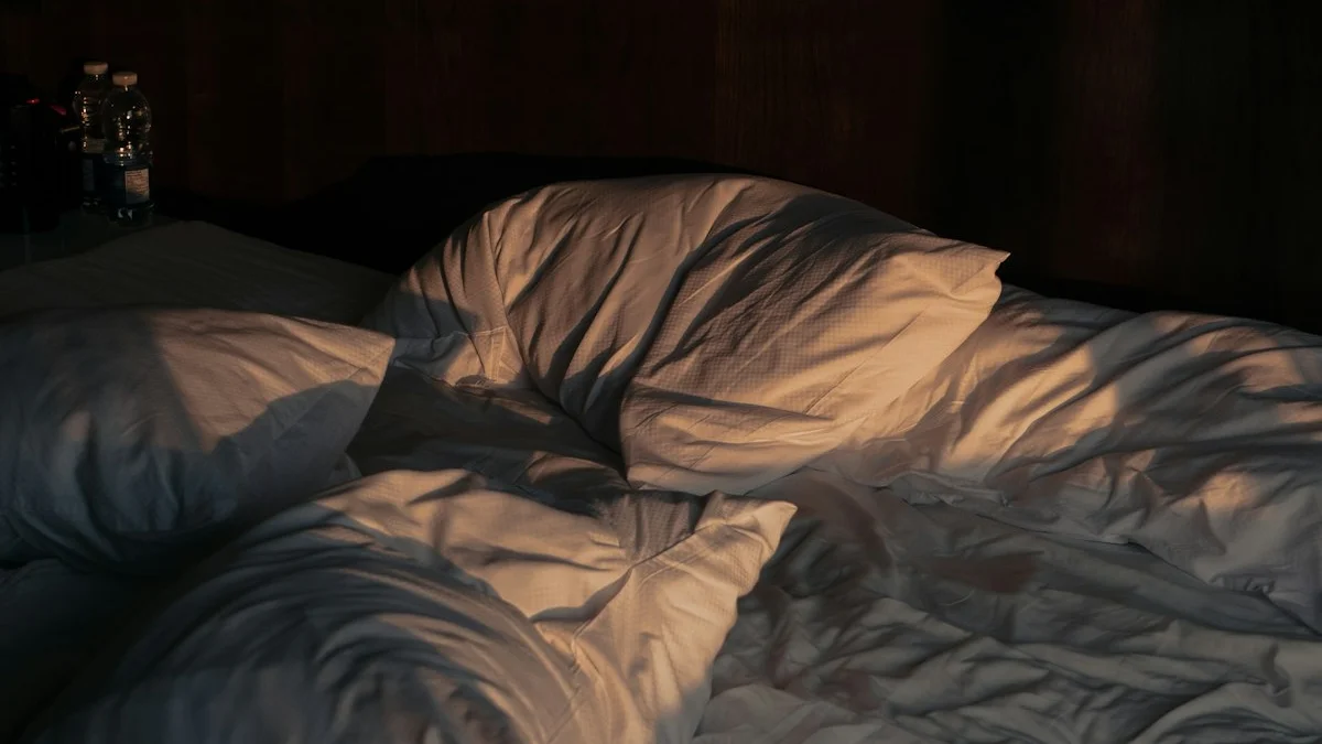 Rumpled white pillows and sheets lie in warm slanting light on an unmade bed. — a The Obsidian Key guide to Falling Asleep in the Seat: What the Receiver Owes.