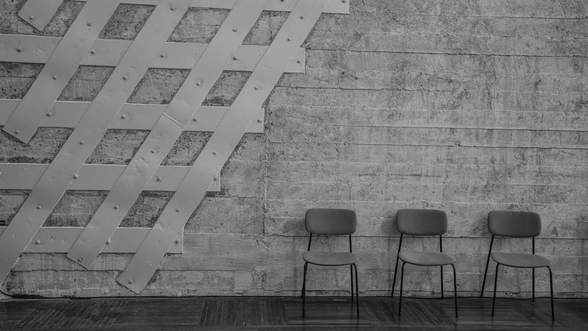 Three empty chairs wait in a row against a concrete wall crossed by white steel bands. — a The Obsidian Key guide to How the Field Casts the People Around You.