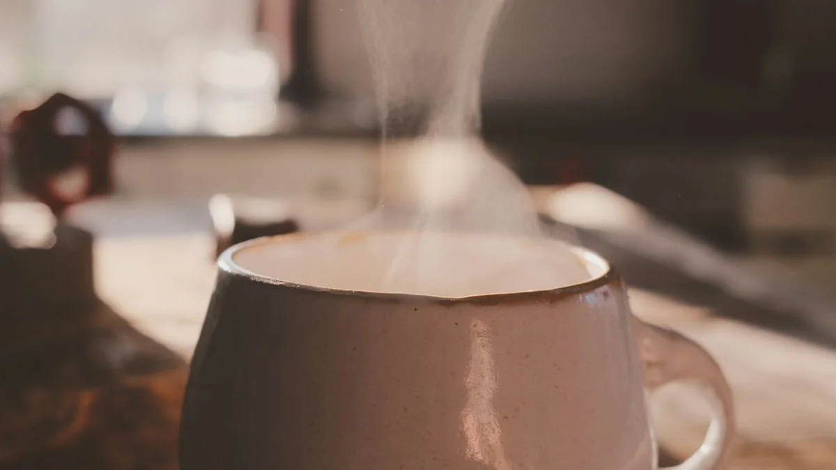 Steam rising from a ceramic cup on a wooden table in soft morning light. — a The Obsidian Key guide to How Long Before the Ritual Stops Feeling Like Effort.