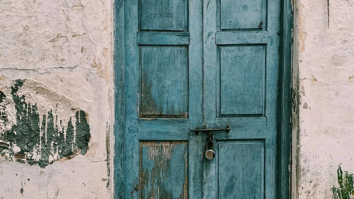 A weathered blue double door with a central latch sits in a crumbling plaster wall. — a The Obsidian Key guide to Manifestation vs Law of Attraction: The Split.