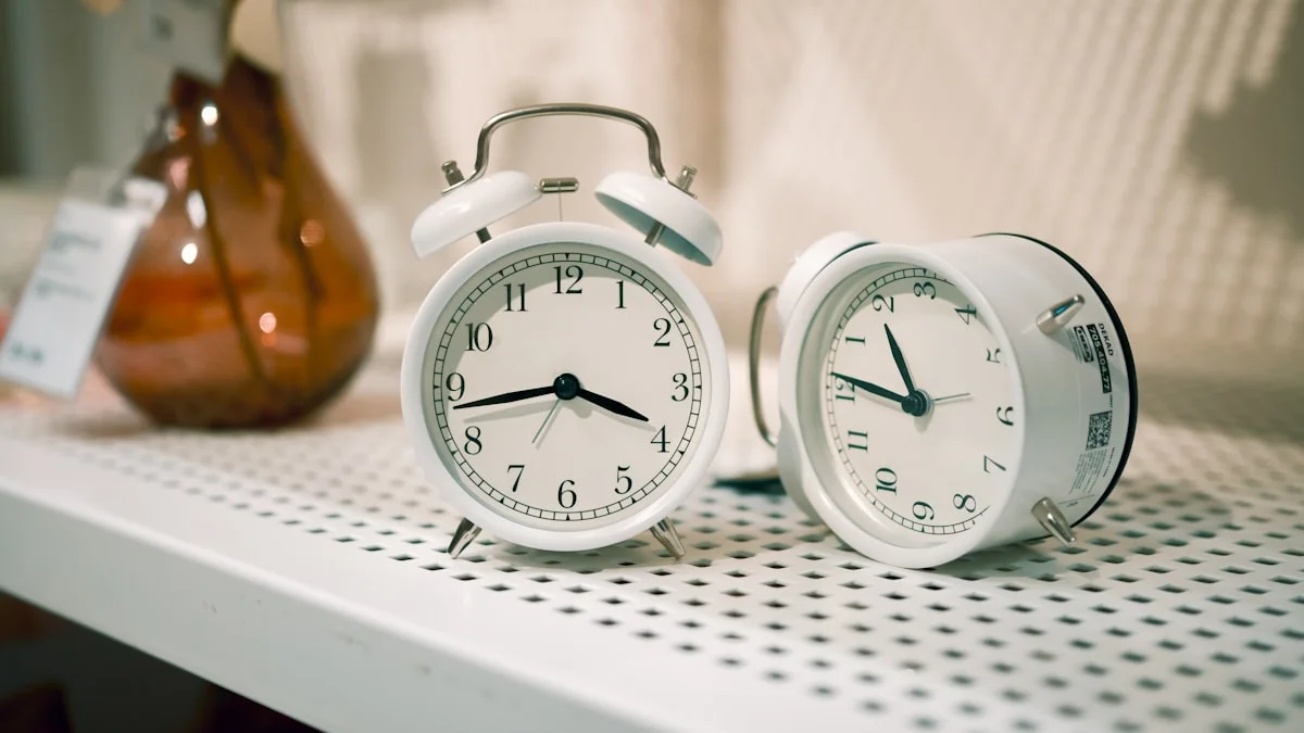 Two small white alarm clocks stand on a pale shelf in soft warm light. — a The Obsidian Key guide to The Minimum Morning: Nine Breaths and One Log Line.