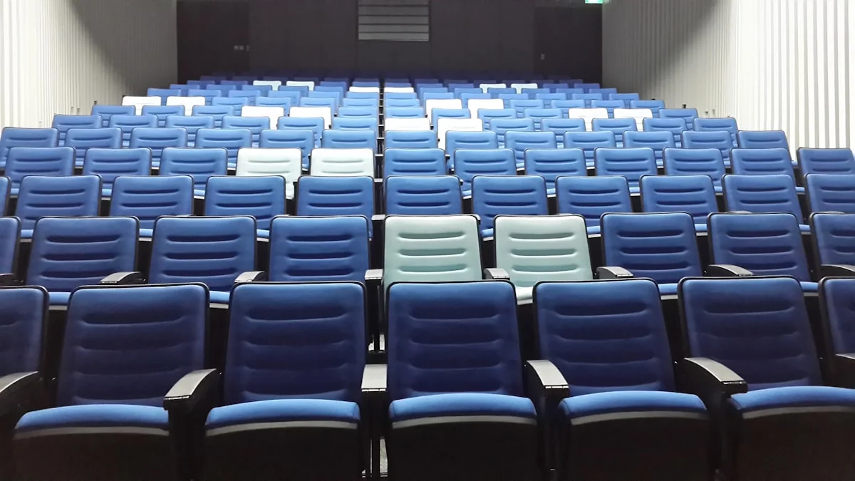Rows of blue seats stand empty in a lecture auditorium. — a The Obsidian Key guide to Money Mindset Courses vs a Field Manual.
