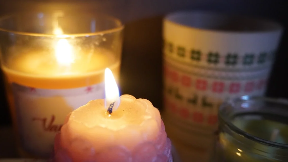 Two lit candles glowing in a darkened room beside a patterned ceramic mug. — a The Obsidian Key guide to Morning and Evening Ritual: The 25 and 10 Minute Split.