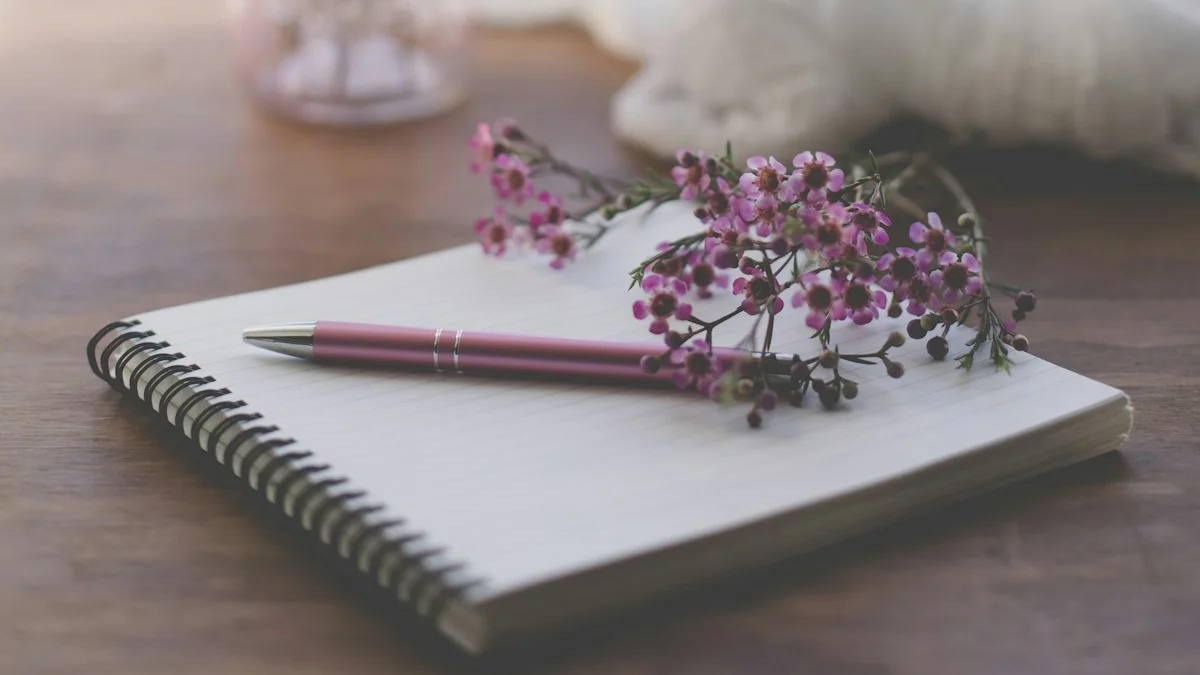 An open spiral notebook with a pen and sprigs of waxflowers rests on a wooden desk in soft morning light. — a The Obsidian Key guide to The Compound Mark: Logging the Morning in Five Minutes.