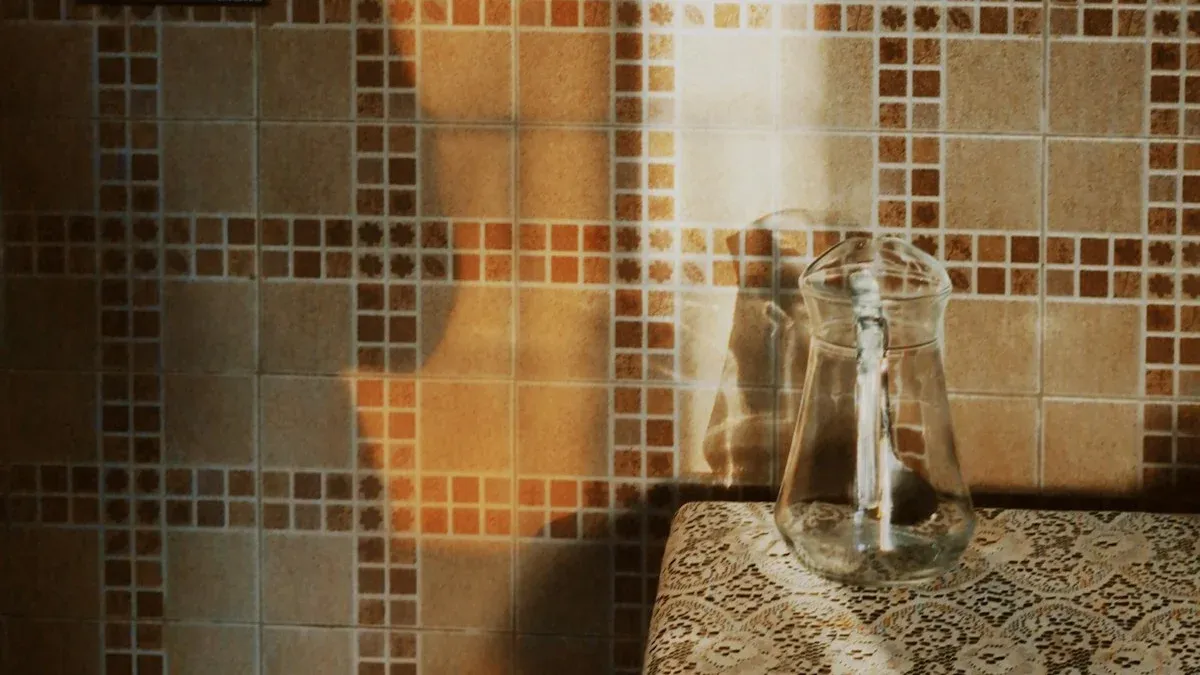 Golden dawn light across a tiled kitchen wall with a glass carafe on a lace-cloth table. — a The Obsidian Key guide to The Morning Ritual of the Key: the Full 25 Minutes.