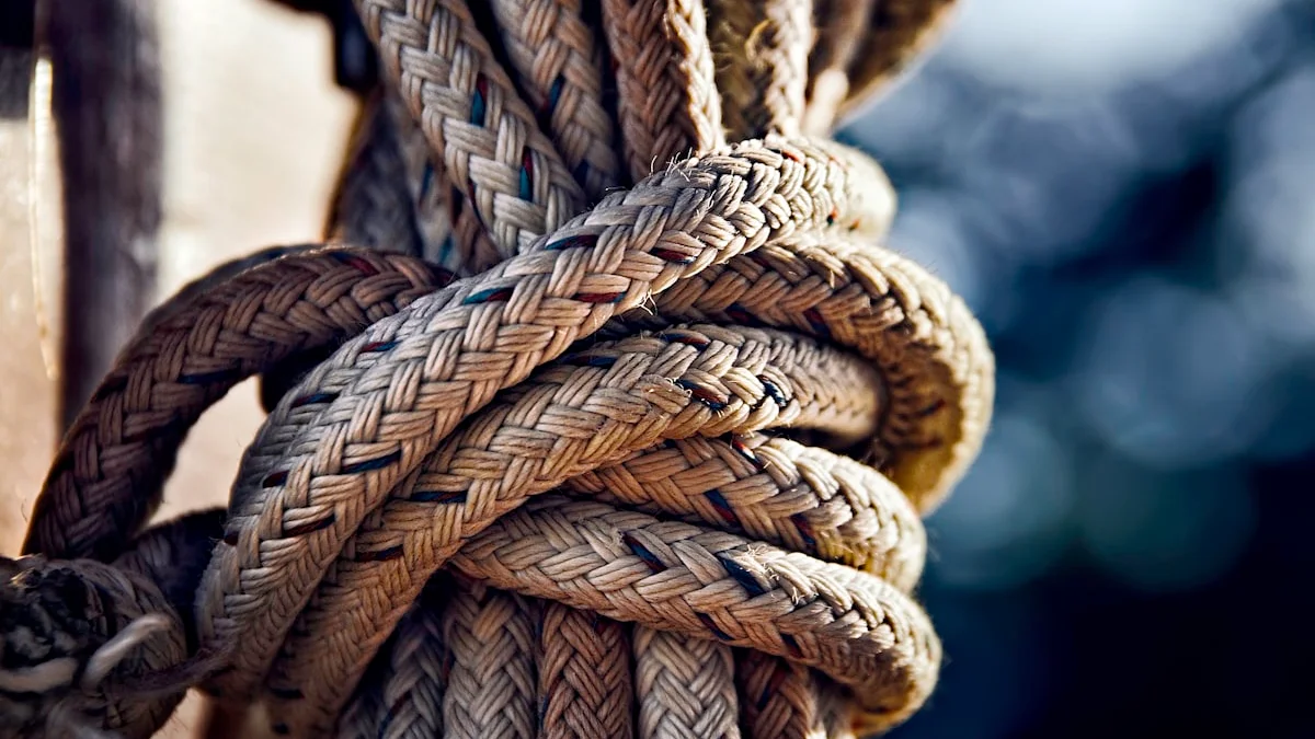 A thick braided rope pulls tight in a knot against a blurred dark background. — a The Obsidian Key guide to Overloaded Signal: What Hidden Overload Does to a Life.