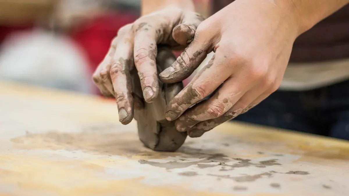 Clay-covered hands shape one small piece of pottery on a wooden workbench. — a The Obsidian Key guide to Practice One Law at a Time: The Reading Rule.