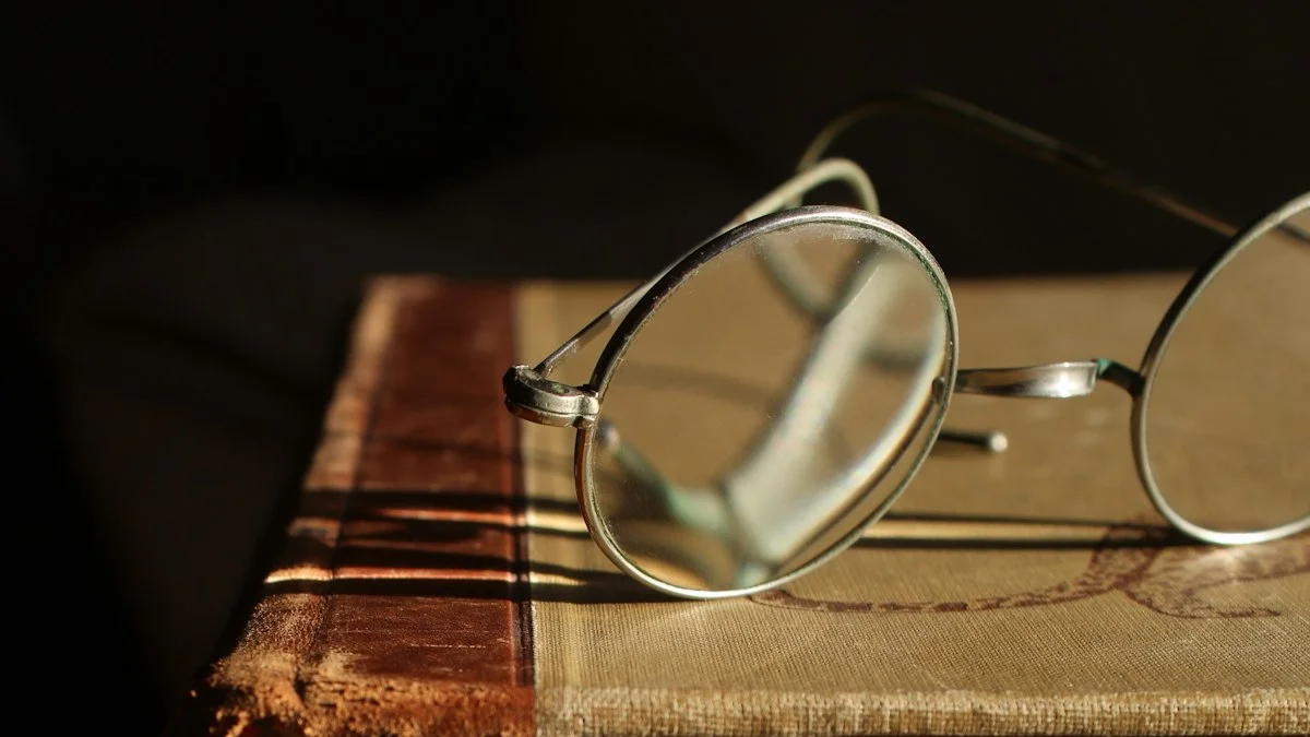 Round reading glasses resting on a worn clothbound book in warm light. — a The Obsidian Key guide to Reading Like a Keeper: Companion Notes.