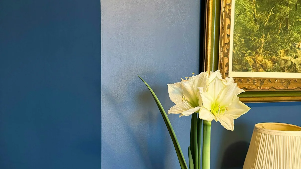 A white amaryllis in a brass pot stands beside a brass lamp and a gilt-framed landscape painting on a deep blue wall. — a The Obsidian Key guide to The Relapse Chapter: What the Book Says About Returning.