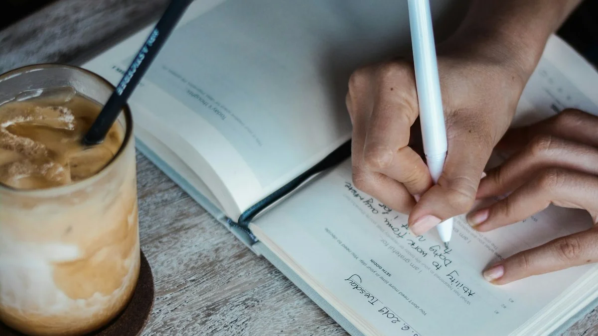 A hand writing a line in an open notebook on a wooden table beside an iced coffee. — a The Obsidian Key guide to The Ritual Logbook: Four Lines Written by Hand.