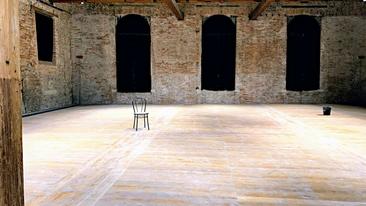 A single bentwood chair stands in the middle of an empty weathered brick room with three dark windows. — a The Obsidian Key guide to Spaces Accrue Signal Residue.