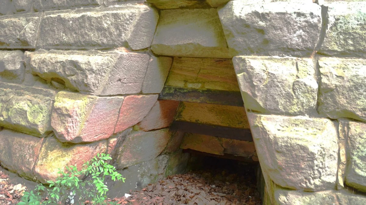 A small dark opening in a rough stone wall forms a low threshold entrance. — a The Obsidian Key guide to Start the Thirty-Day Path: The Day Zero Checklist.