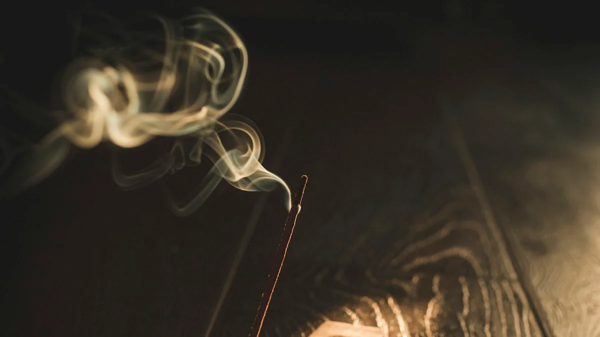 A thin ribbon of smoke rises from an incense stick on a wooden holder in warm darkness. — a The Obsidian Key guide to Stillness Mistakes: Turning the Seat Into a Performance.