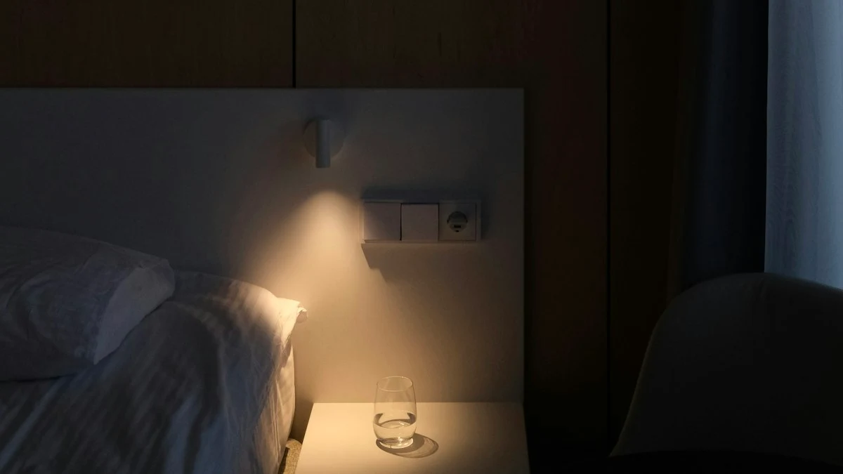 A warm bedside lamp glowing over linen bedding and a glass of water in a quiet room. — a The Obsidian Key guide to The Nine Breaths: The First Practice Defined.