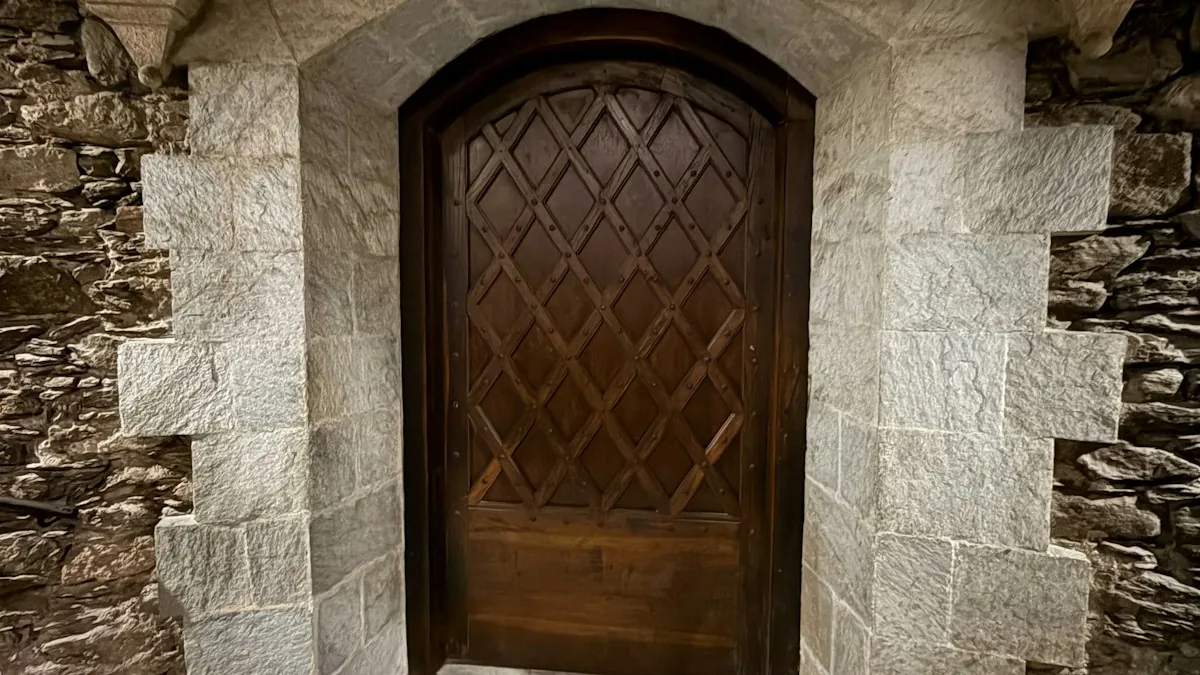 A dark arched wooden door is set into the stone wall of an old building. — a The Obsidian Key guide to The Silent Center: The Room Where the Signal Is Written.