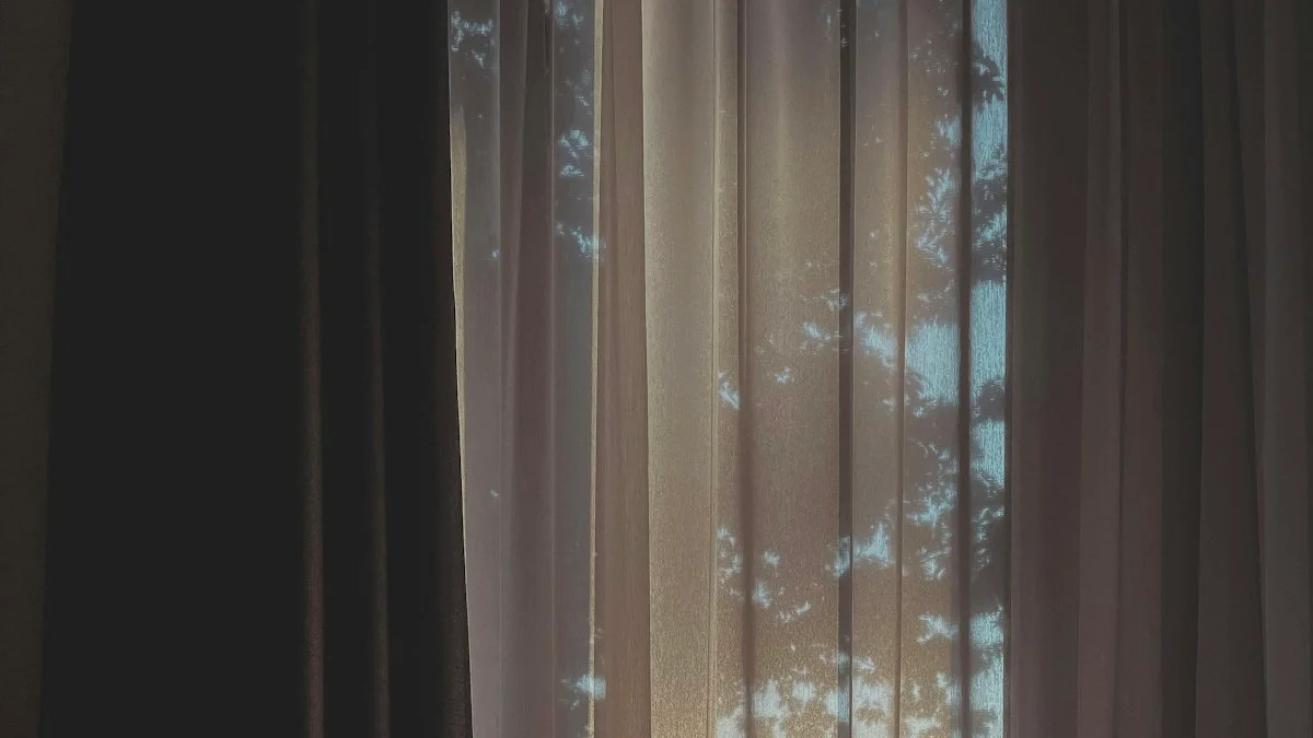 A sheer curtain half drawn across a window glows with warm dusk light behind it. — a The Obsidian Key guide to Where the Veil Doctrine Comes From.