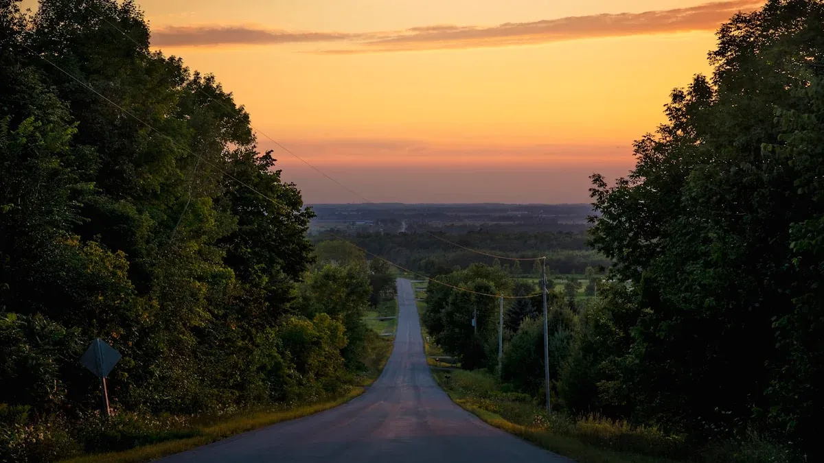 A long straight country road runs between dark trees toward a glowing sunset horizon. — a The Obsidian Key guide to The Thirty-Day Path: A Week-by-Week Program Guide.