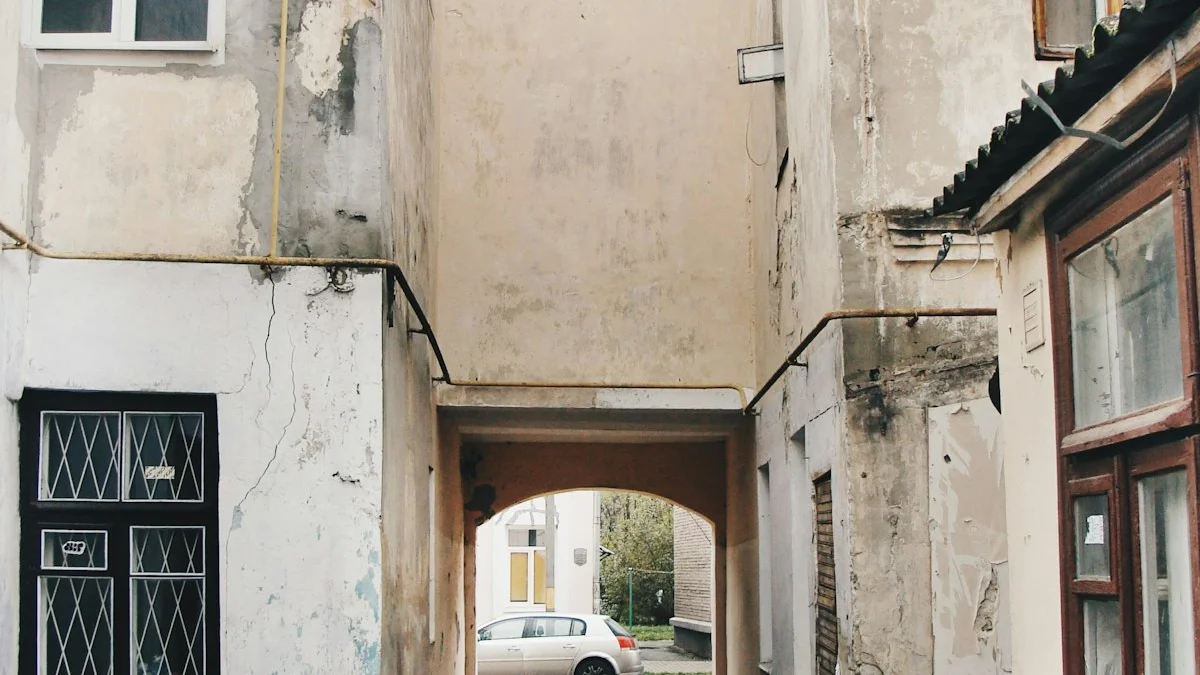 A weathered archway between two old plaster buildings opens onto an unfamiliar side street with a car parked in the distance. — a The Obsidian Key guide to Week Four of the Path: The Flame and the Unmarked Path.