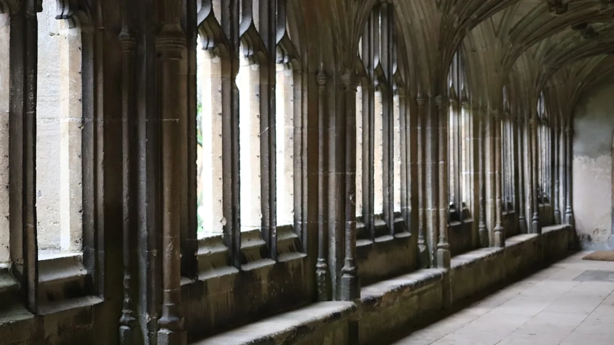 A vaulted stone corridor with Gothic arched windows recedes into shadow. — a The Obsidian Key guide to What Is Reality Architecture: The Layer Beneath Events.