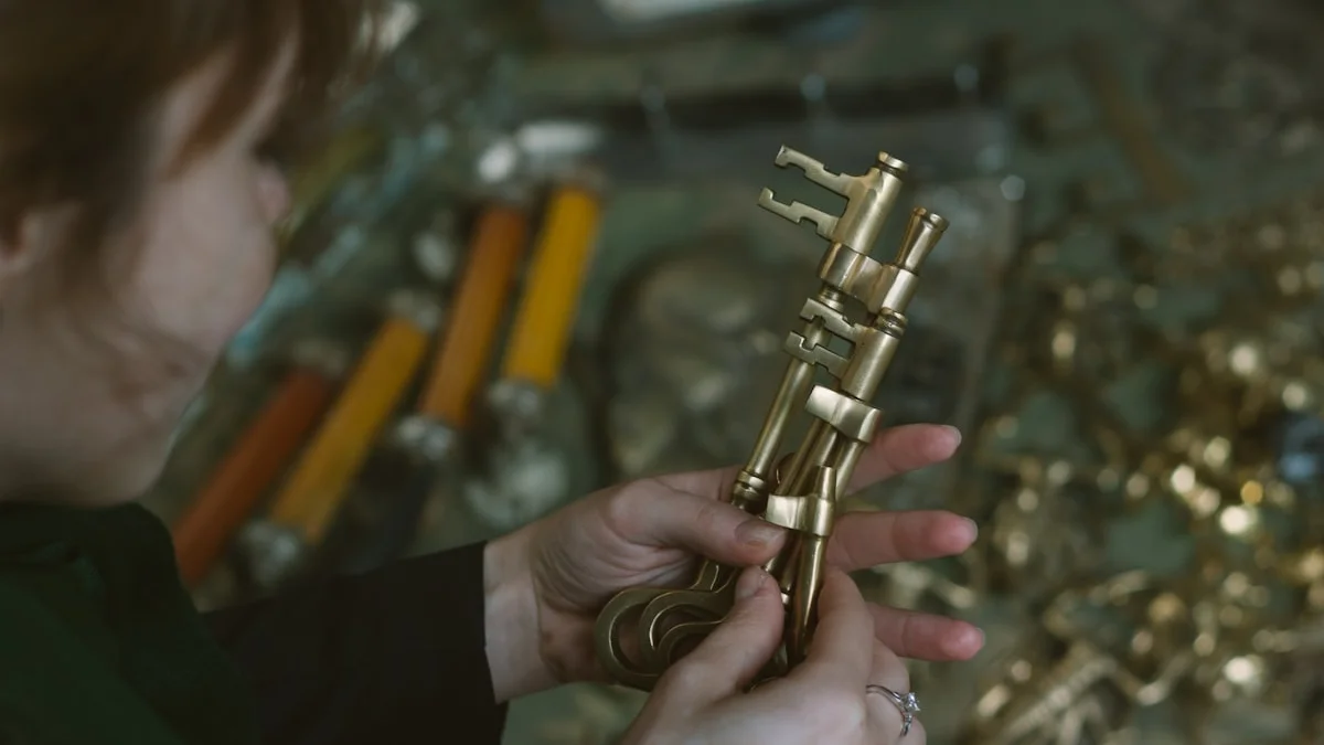 Hands in profile hold an ornate brass key above a workshop table of brass parts. — a The Obsidian Key guide to Who Are You Being: The Question Behind Every Goal.