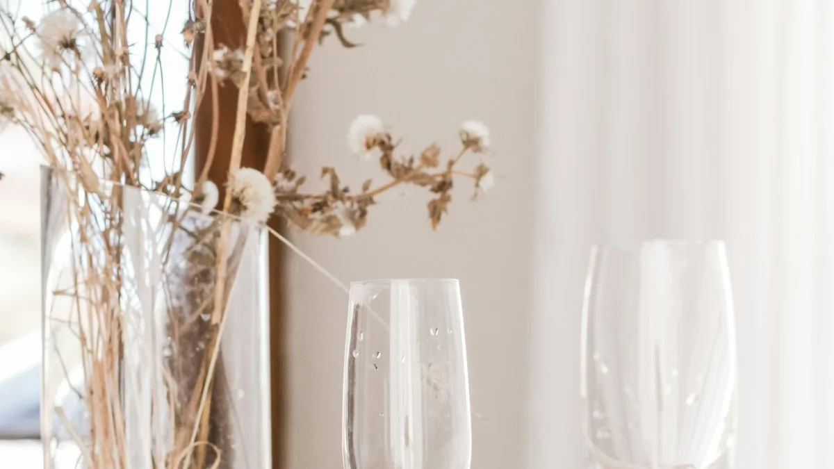 A dinner table set with two champagne glasses, dried flowers, and bread in soft evening light. — a The Obsidian Key guide to Why Your Practice Holds Everywhere Except Home.
