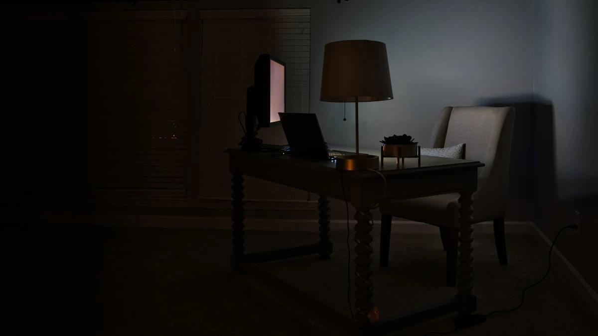 A dark office at night lit by a single desk lamp over a closed laptop and an empty chair. — a The Obsidian Key guide to Work Boundaries Without Burning Bridges: Time Boxing.