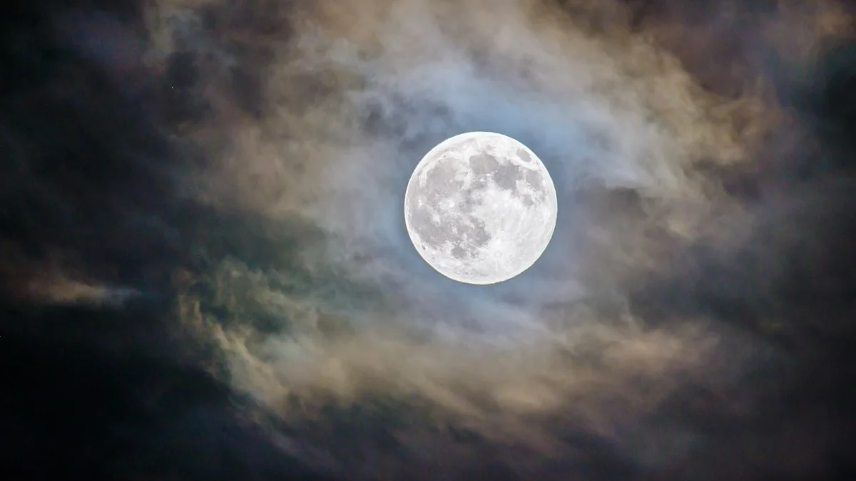 A bright full moon glows behind drifting gray clouds at night. — a The Obsidian Key guide to Worry as a Parasite: The Leak With No Event.
